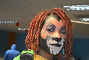 Kimani Jones looks at the camera with her face painted to look like Scar from The Lion King.